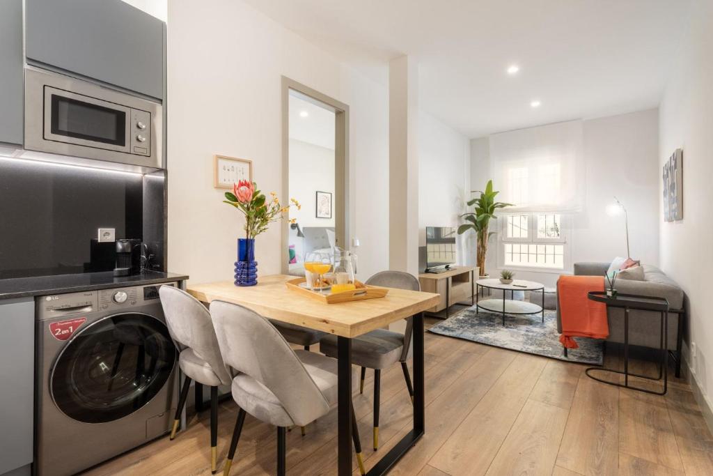 a kitchen and living room with a table and a washing machine at Apartamento para 4 en Chamberi Quevedo V in Madrid