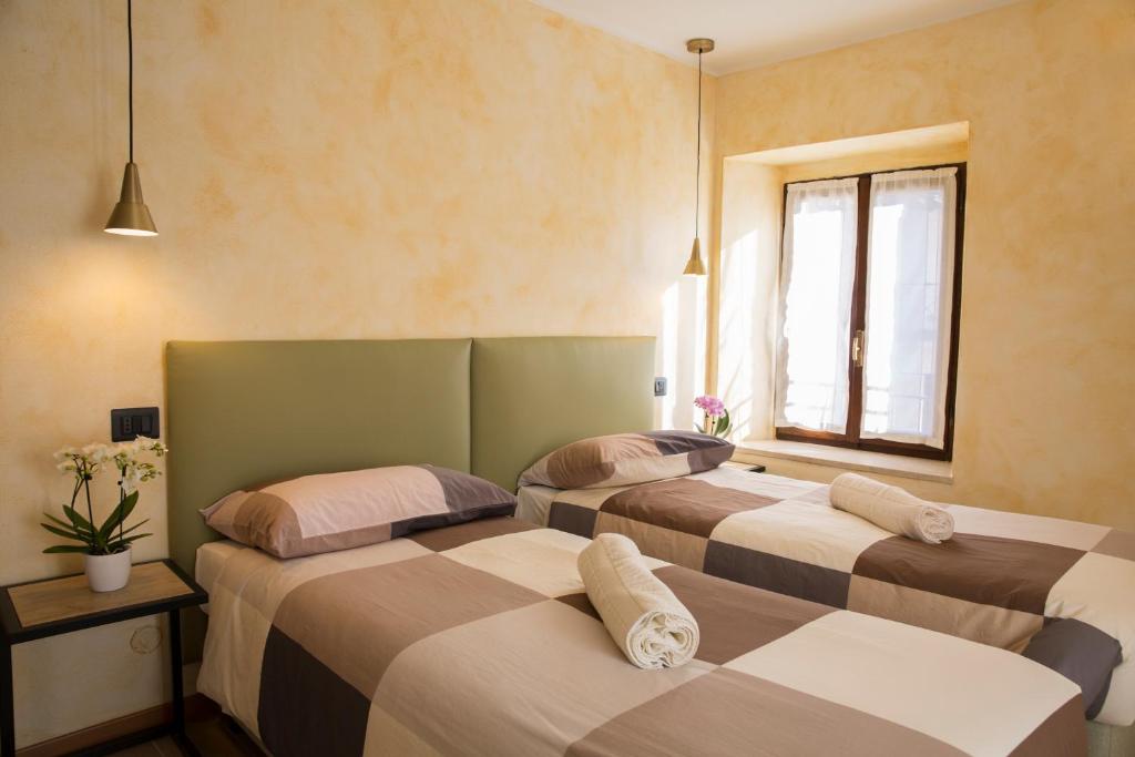 three beds in a room with a window at Albergo Ristorante Da Elia in SantʼOmobono Imagna