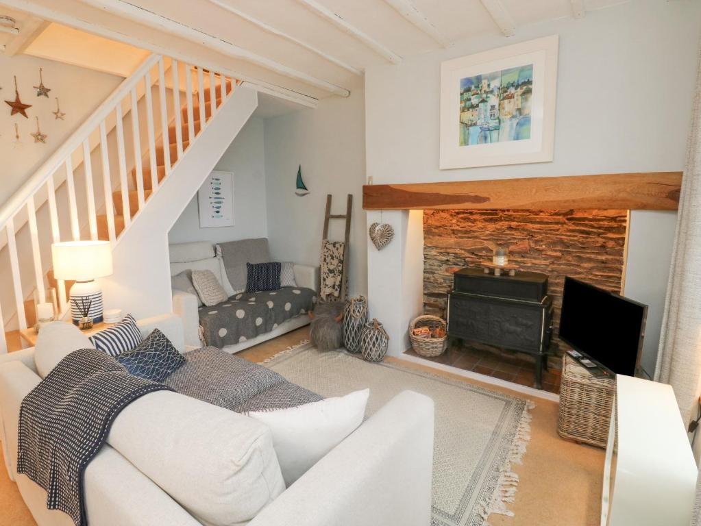 a living room with a white couch and a fireplace at 6 Hillside Terrace in Dartmouth