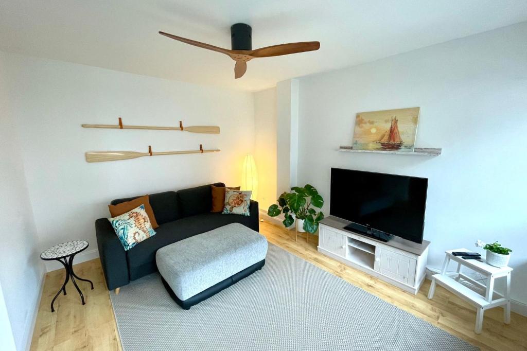 a living room with a couch and a flat screen tv at YourFavoriteBed I Zentral, Gemütlich, Perfekt für Entspannung! in Bremerhaven
