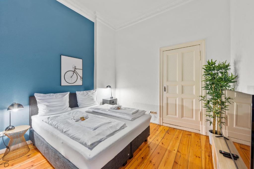 a bedroom with a large bed with a blue wall at primeflats - Apartment Leberstr 58 Berlin Schöneberg in Berlin