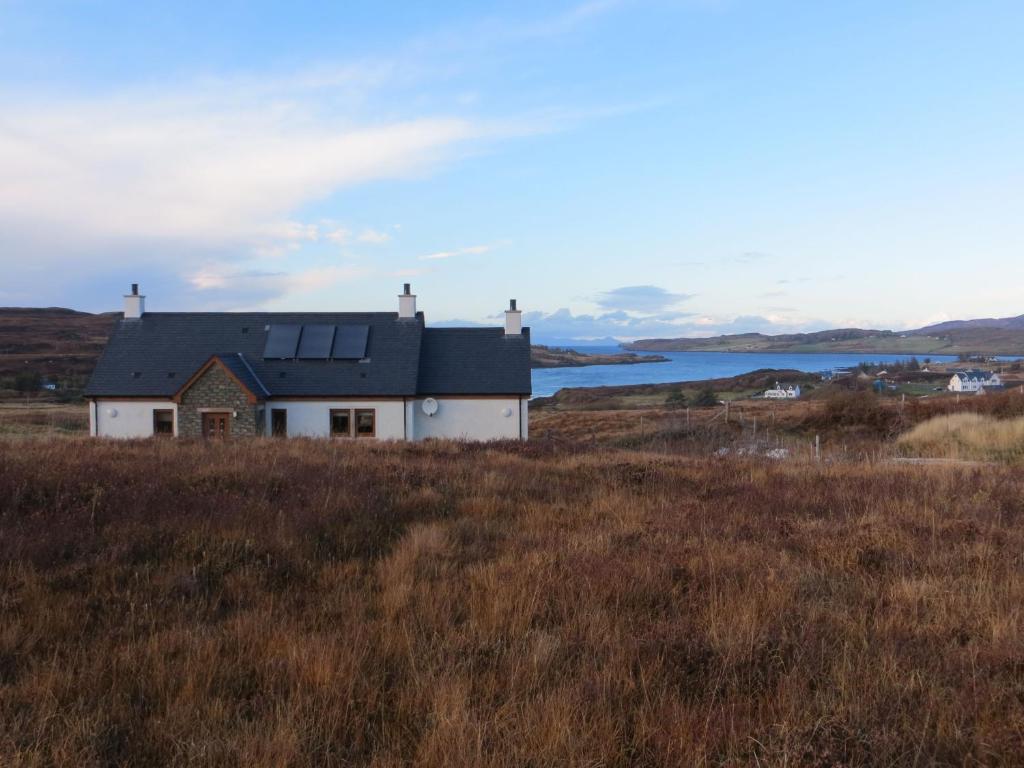 a house in the middle of a field at Hill Cottage in Kensaleyre