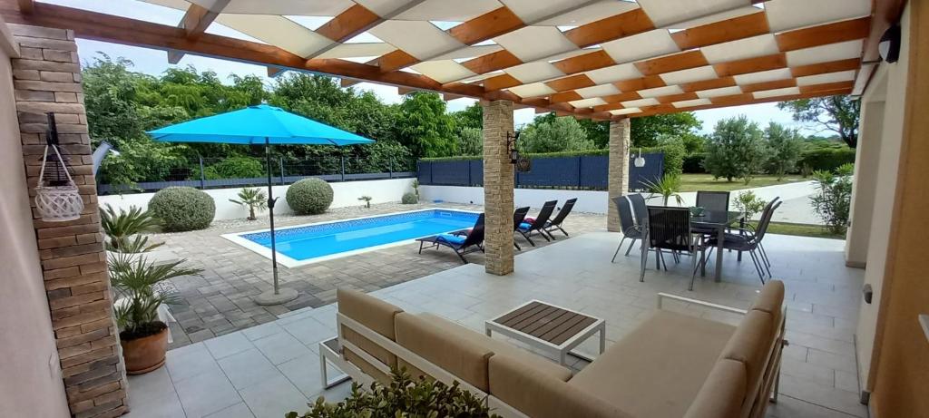 une terrasse avec une table, des chaises et une piscine dans l'établissement Happy House, à Zadar