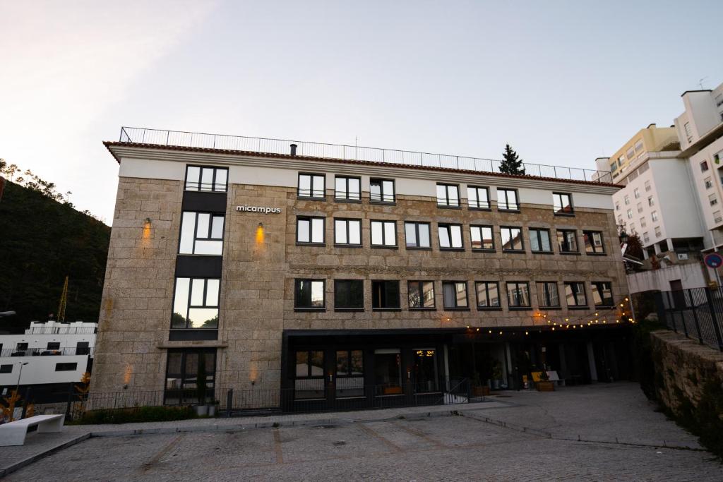 um grande edifício de tijolos com muitas janelas em micampus Covilhã na Covilhã