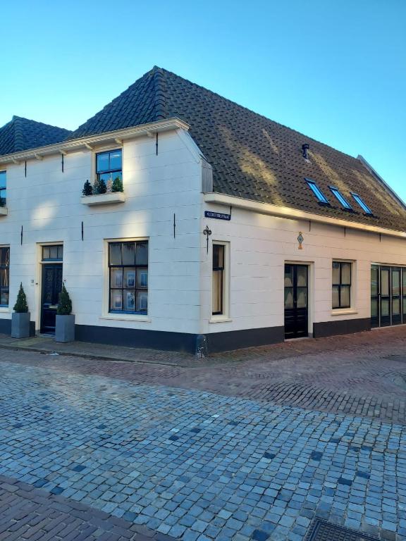 a white building with a black roof and windows at De Kapelle in Oudewater in Oudewater
