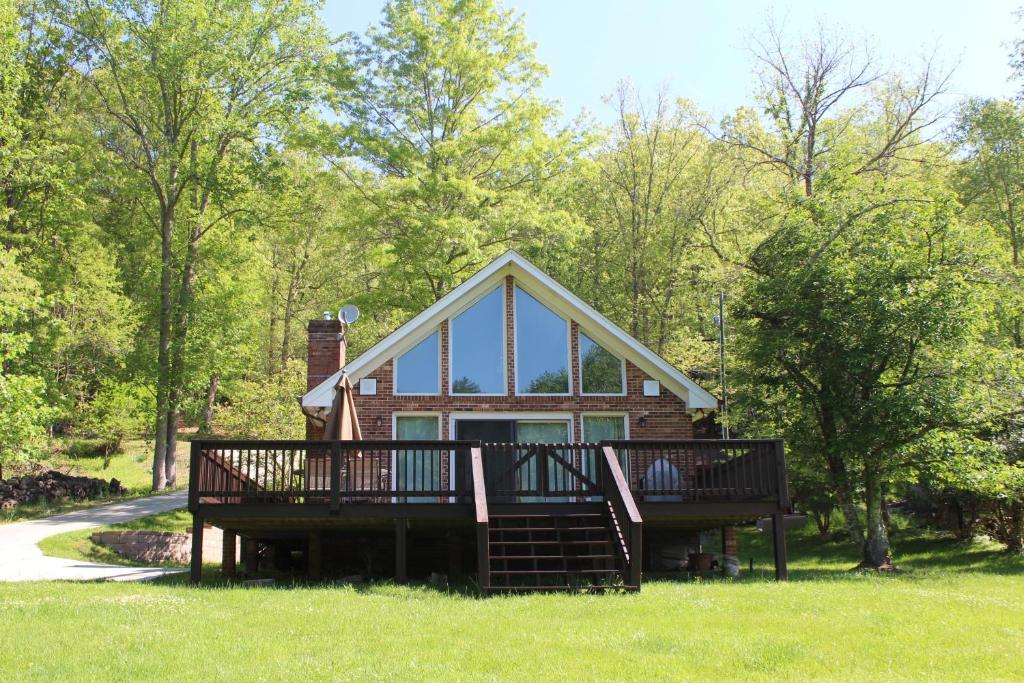 a home with a large deck and a house at Riverside Escape in Piney Creek