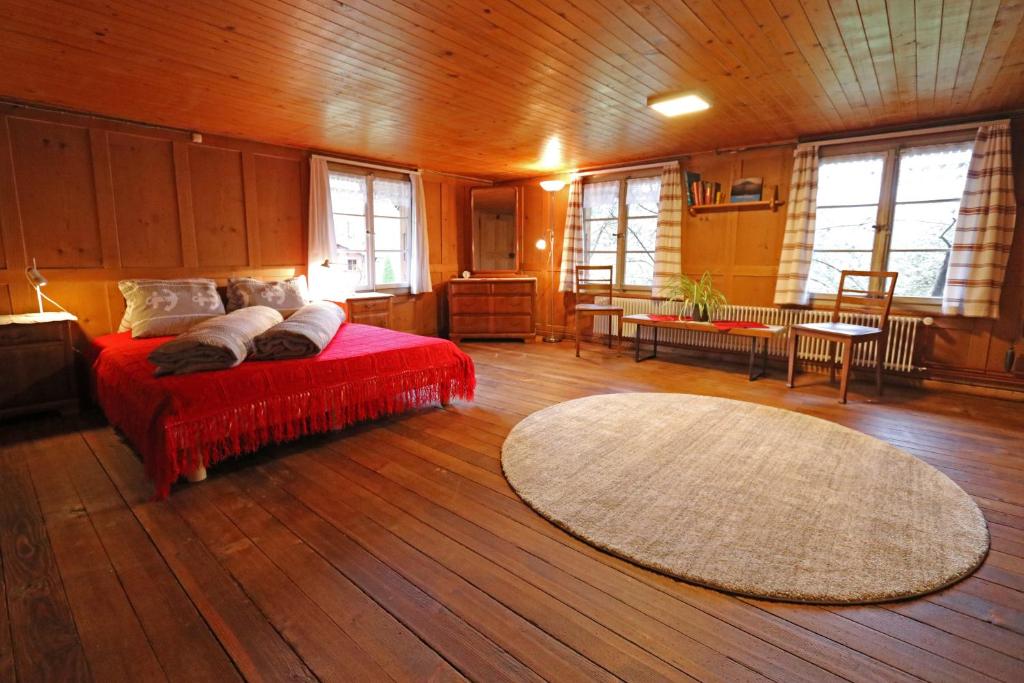 een slaapkamer met een rood bed en een tapijt bij Emmental Ferien in Langnau