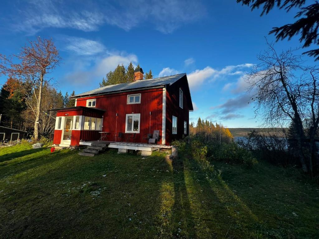 a red house sitting on top of a green field at Simple charming Double-room close to nature in Hillsand