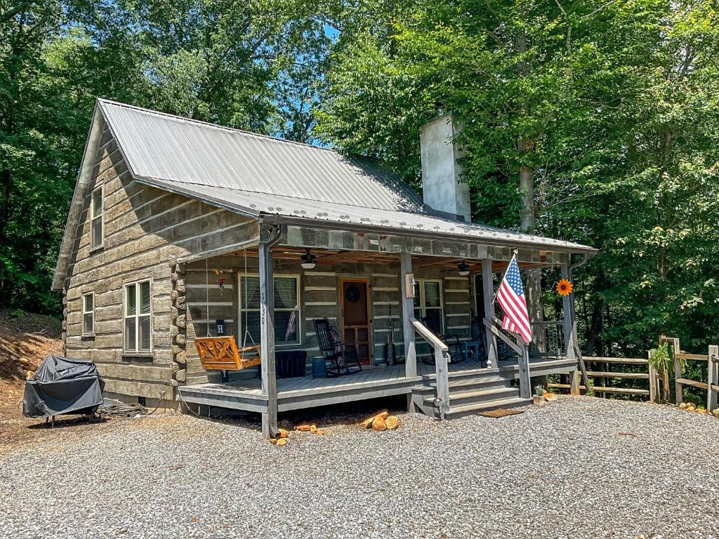 uma pequena cabana com uma bandeira americana à frente. em Reddies River Retreat - New Rental 2023 em Millers Creek