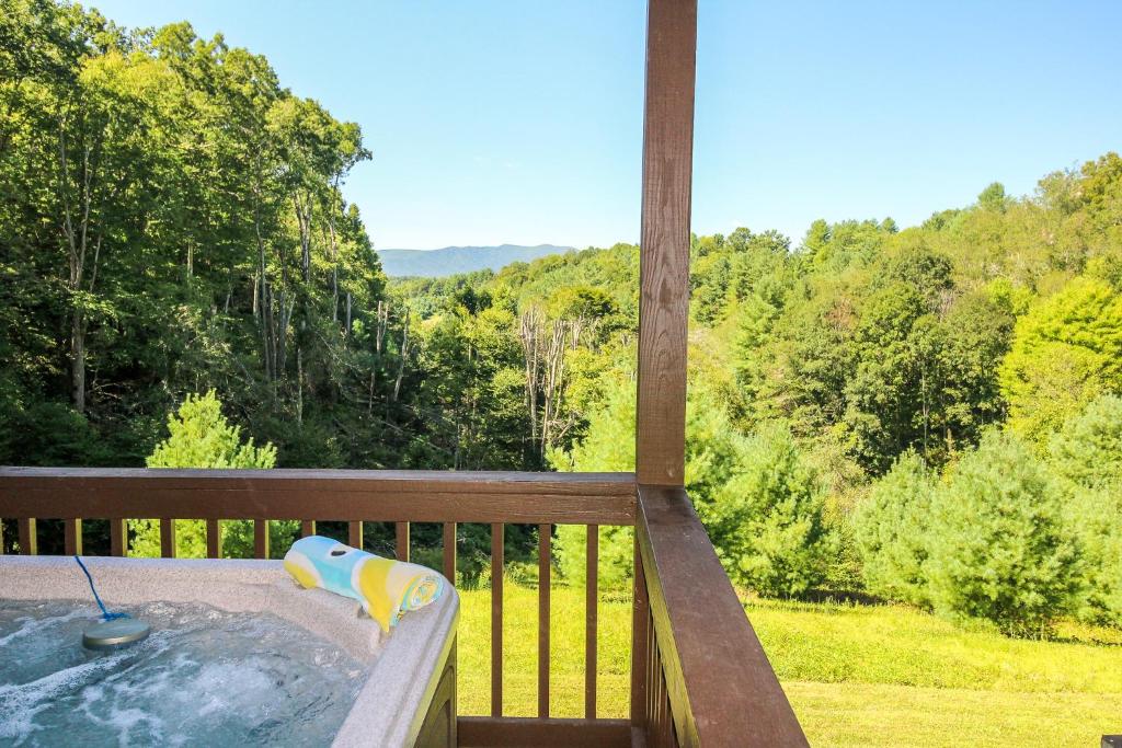 un bain à remous sur une terrasse avec vue sur les bois dans l'établissement Dream Mountain Lodge, à Grassy Creek
