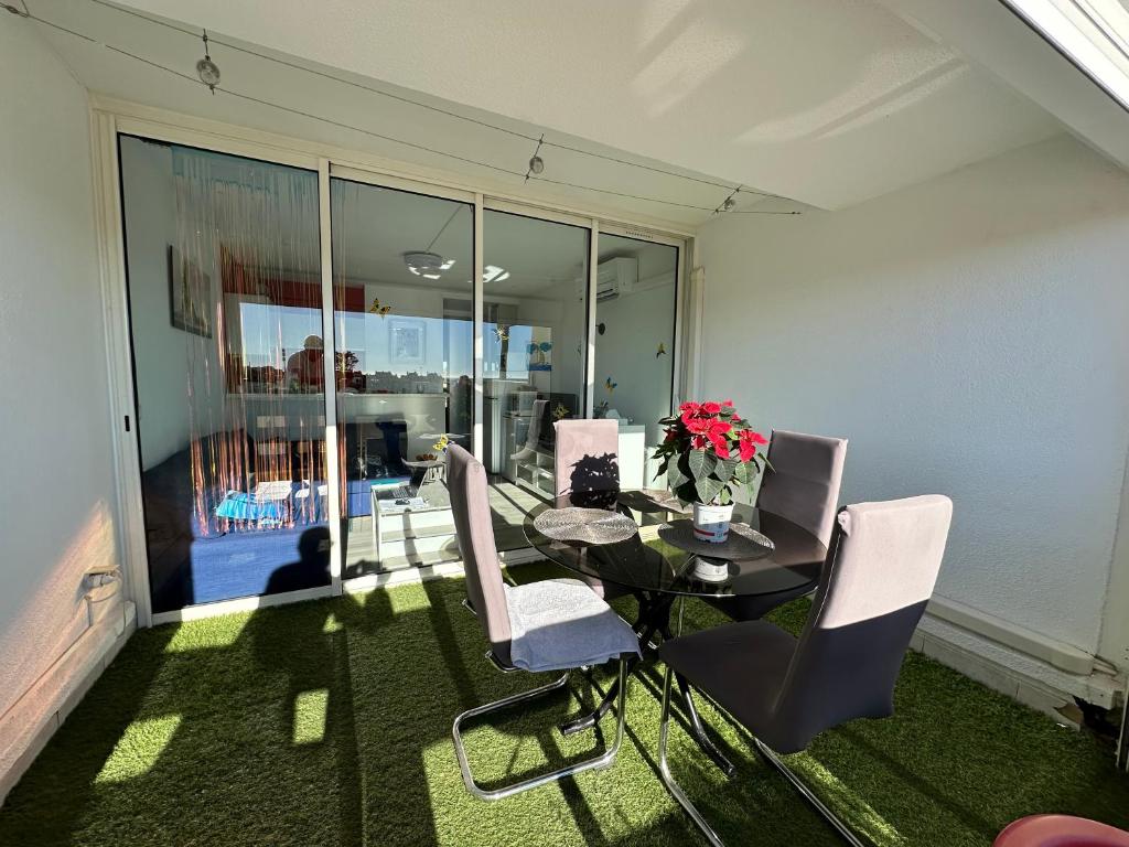 une salle à manger avec une table et des chaises blanches dans l'établissement Village naturiste - Port-Nature 4 coursives vue mer - Le Point G., au Cap d'Agde