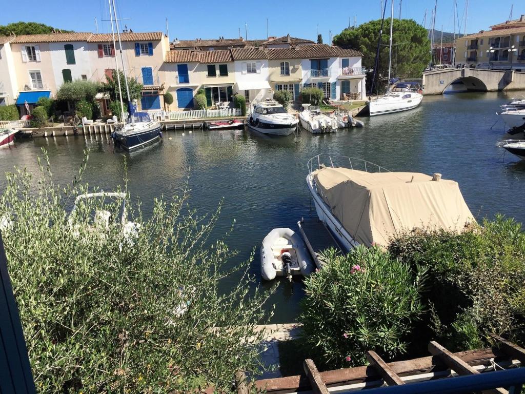 un bateau est amarré dans une rivière avec des maisons dans l'établissement Maison Bleu, à Grimaud