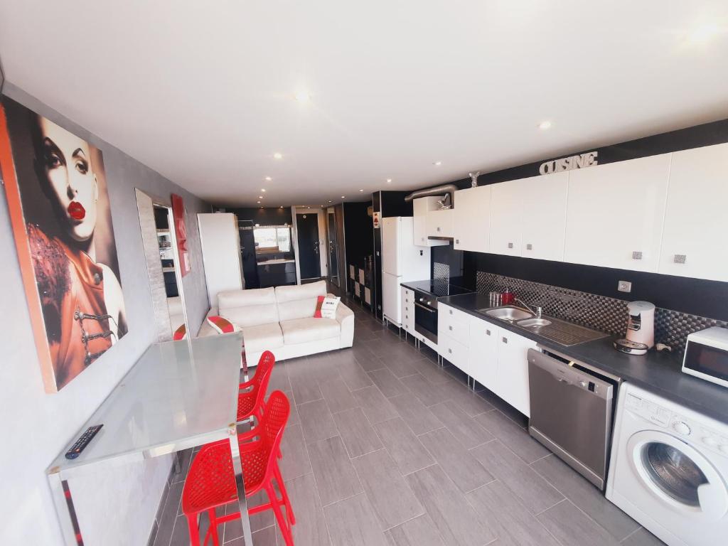 una gran cocina con sillas rojas en una habitación en "L'eden" village naturiste cap d'agde, en Cap d'Agde