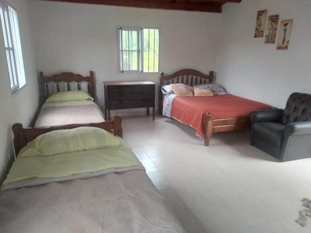 1 dormitorio con 2 camas, sofá y silla en Las talas casa de vacaciones en Santa Florentina