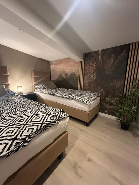 2 letti in una camera con un dipinto sul muro di Zielona Góra Apartament a Jugów