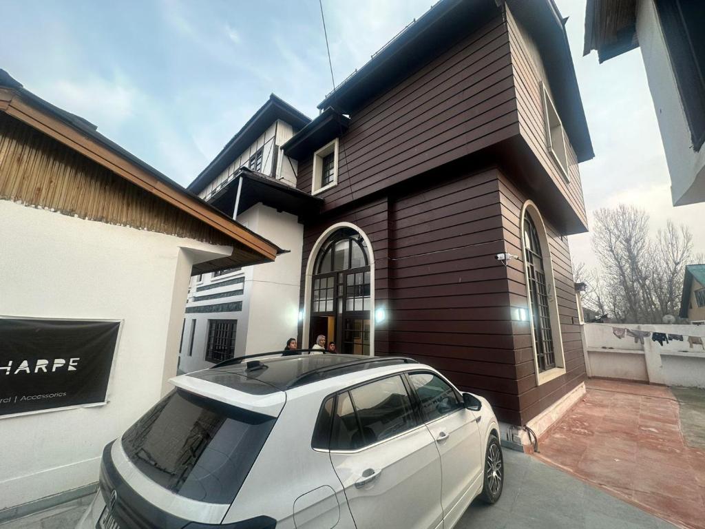 a white car parked in front of a house at Main Street Inn in Srinagar
