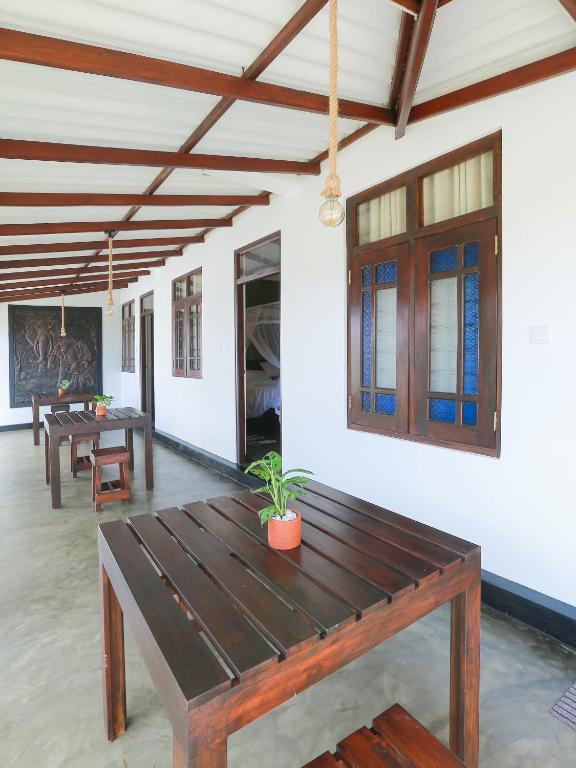 a dining room with wooden tables and windows at Sea View Villa in Hikkaduwa