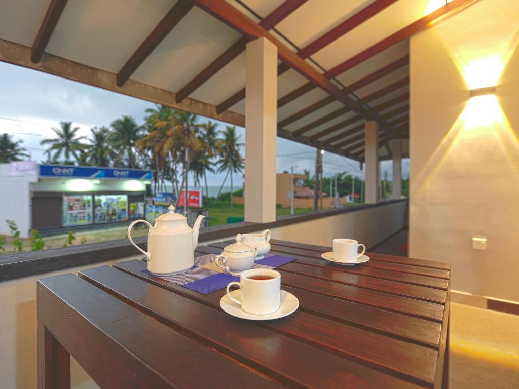 a wooden table with cups and teapots on it at Sea View Villa in Hikkaduwa