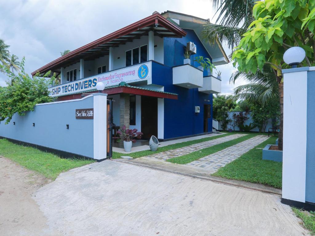 a blue building with a sign in front of it at Sea View Villa in Hikkaduwa