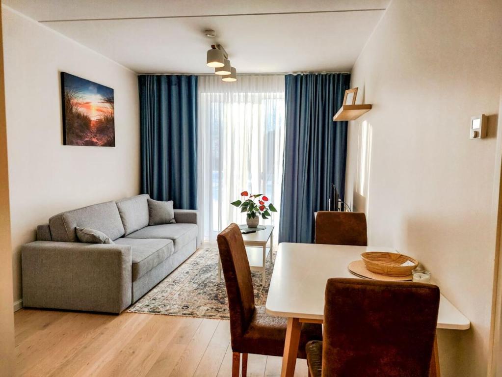 uma sala de estar com um sofá e uma mesa em Mai 71 Johanna suvekorter em Pärnu