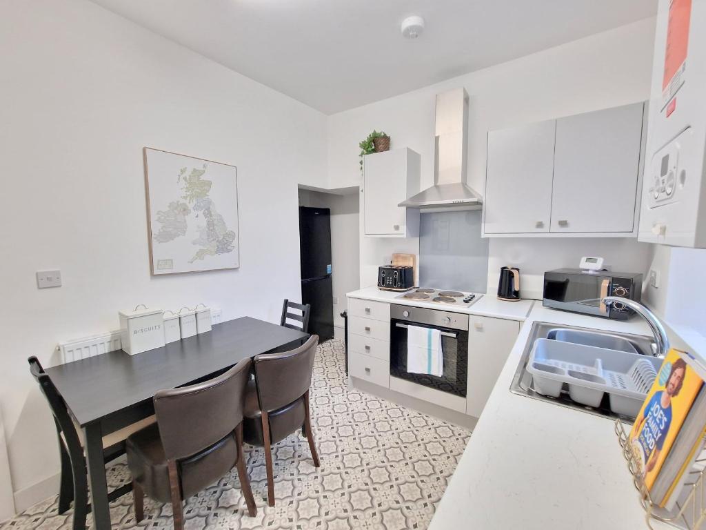 a kitchen with a table and chairs in a room at Burnley Terraced House by BEVOLVE - Free Parking 2 in Burnley