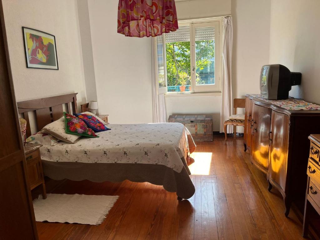 um quarto com uma cama, uma cómoda e uma janela em en el corazón del Barrio Sur em Montevidéu