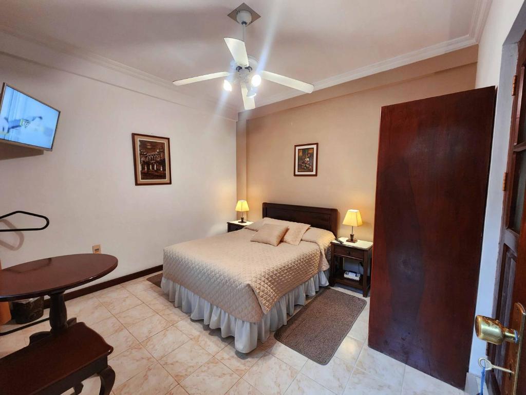 1 dormitorio con 1 cama y ventilador de techo en Hotel Carmen, en Tarija