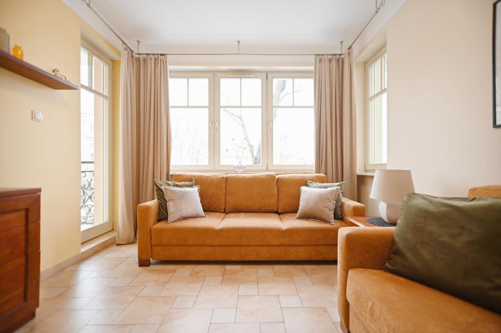 a living room with a couch and two windows at Victus Apartamenty, Apartament Daria Luiza in Sopot