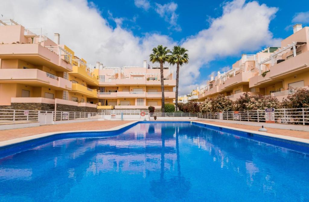 a swimming pool in front of apartment buildings at NEW !! Two Bedroom Cabanas Tavira - Banda Musical ORANGE in Tavira