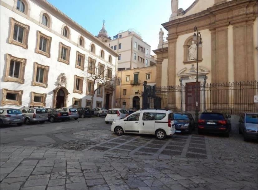 une voiture blanche garée dans un parking à côté d'un bâtiment dans l'établissement Home Casa Professa 1, à Palerme