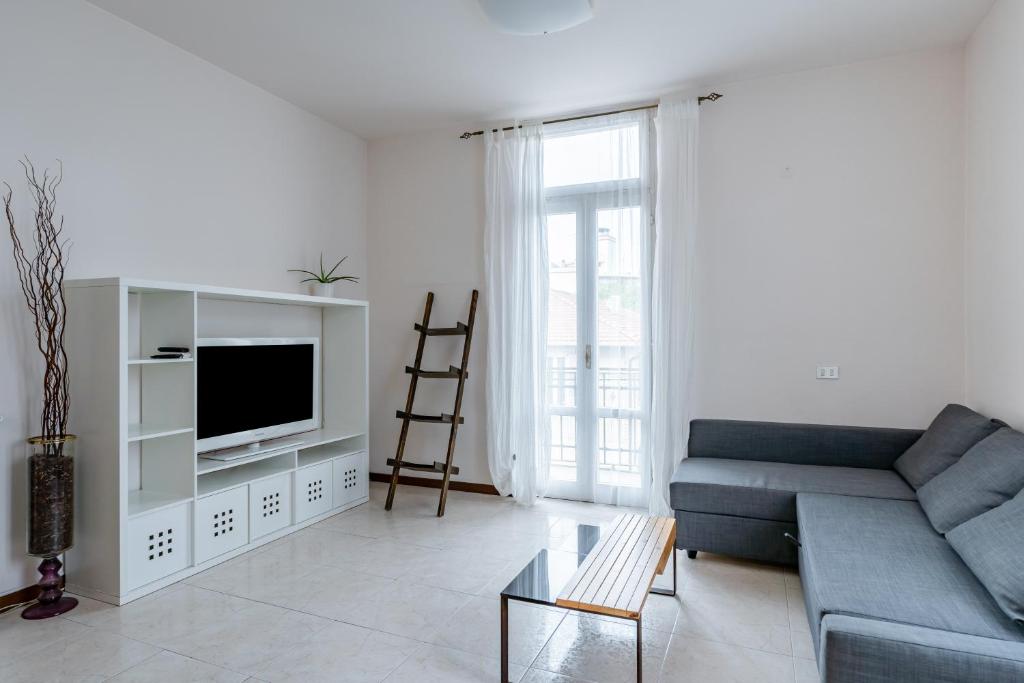 een woonkamer met een bank en een tv bij Apartment in Via Cremona - Brescia City - by Host4U in Brescia