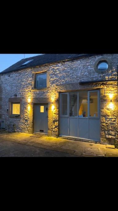 a brick building with two doors and lights on it at Barn Cottage in Youlgreave