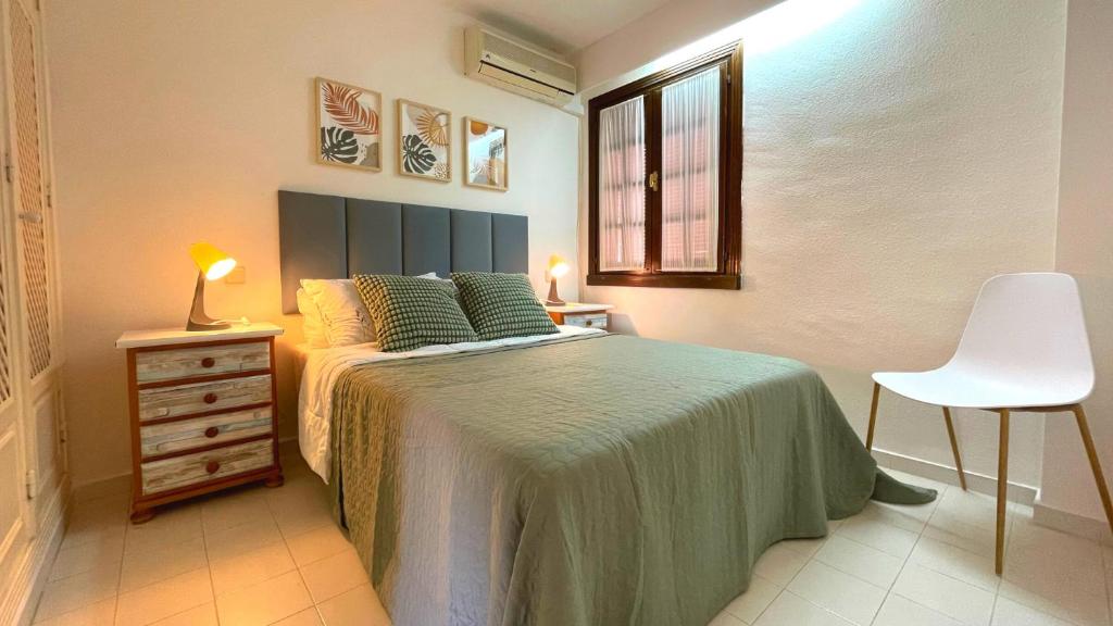 a bedroom with a bed and a chair and a window at Casa Nalon by SunshineClub in Los Alcázares