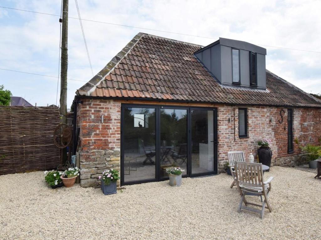 a small brick house with a black roof at Hares Barn in Trowbridge
