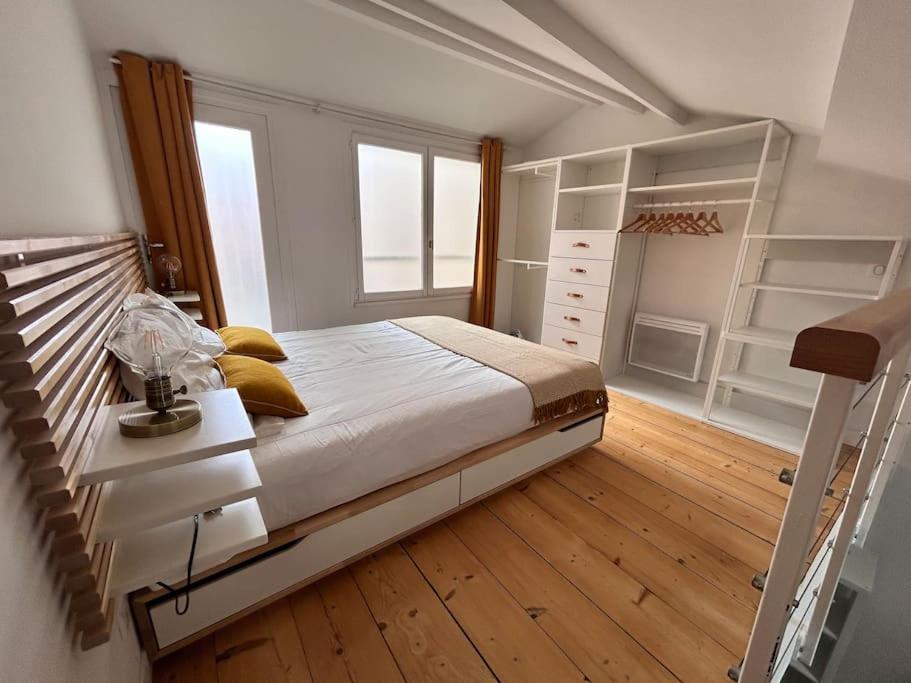 - une chambre avec un grand lit et du parquet dans l'établissement Appartement - Carmes, à Toulouse