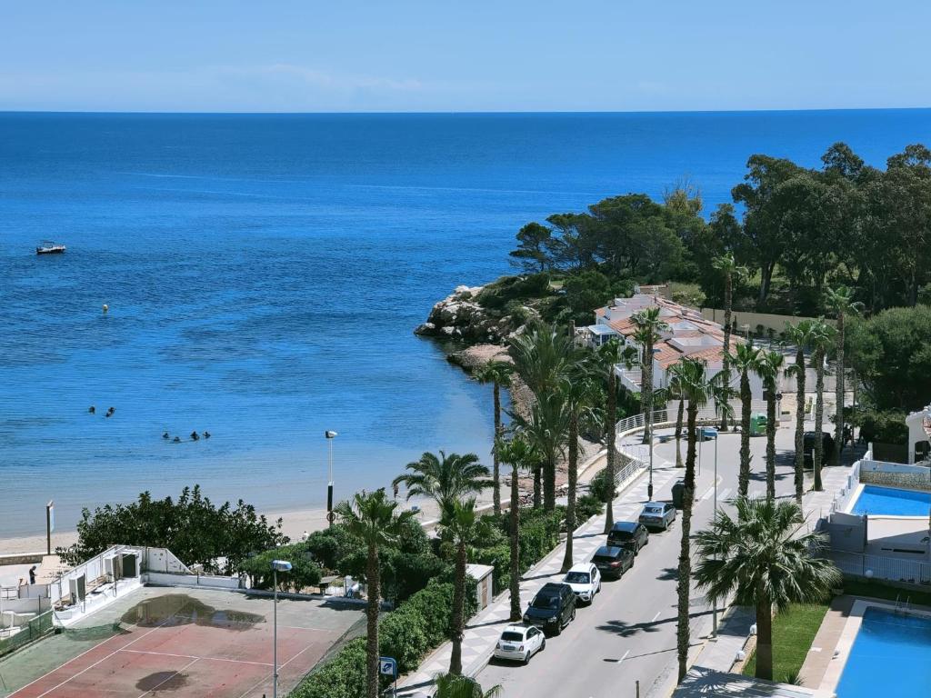 uma vista para uma rua com palmeiras e o oceano em Precioso estudio primera linea Fossa-Puerto Calpe em Calpe