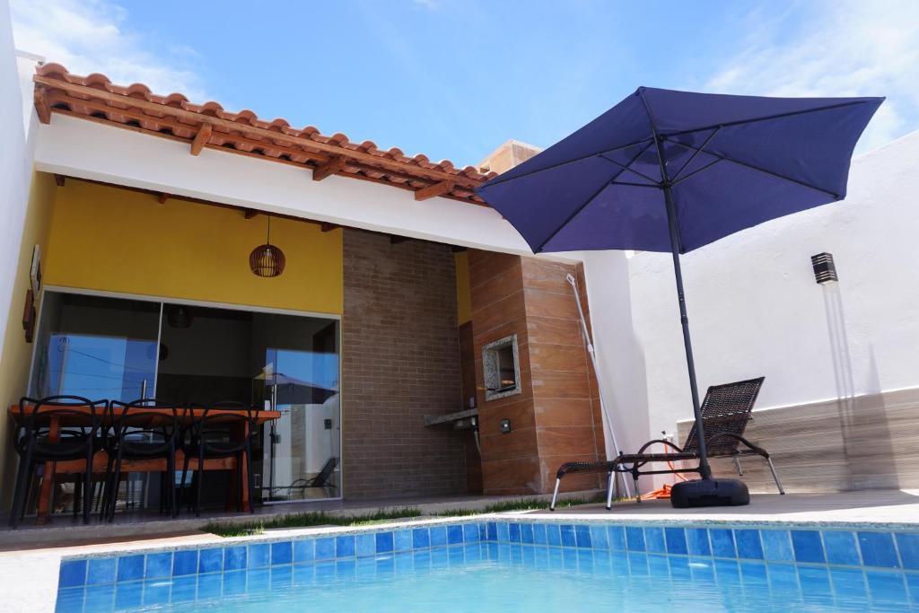 niebieski parasol siedzący obok basenu w obiekcie ESTRELA DO MAR w mieście Prado