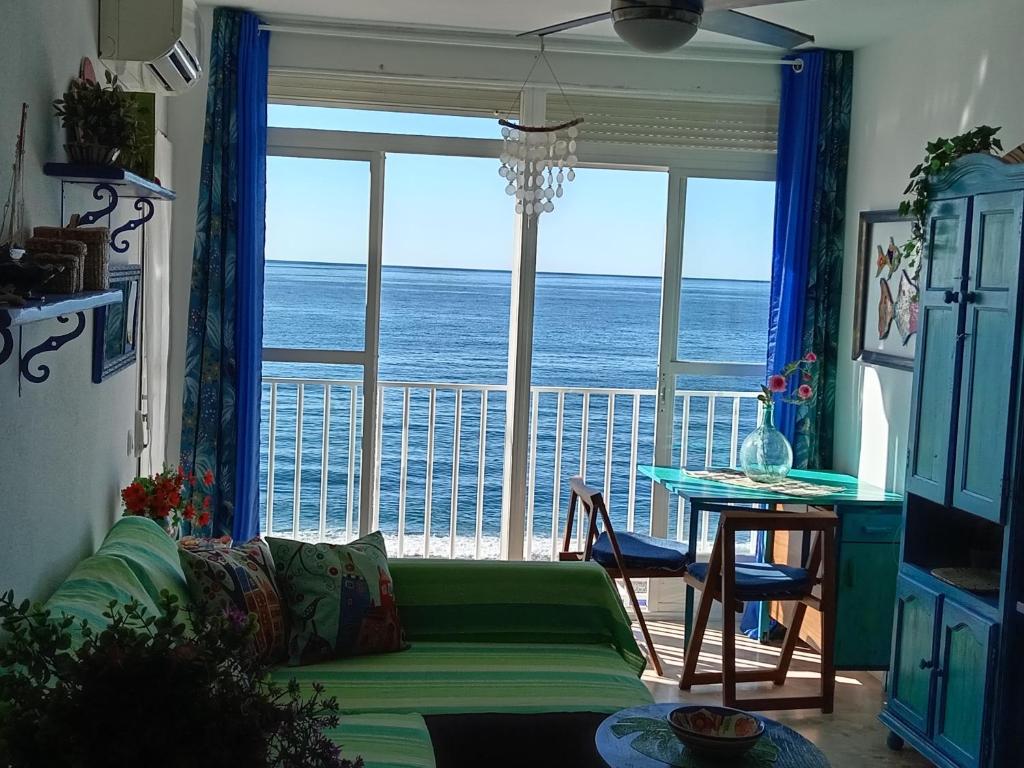 a living room with a couch and a view of the ocean at Vistas al Mar Mediterraneo in Melicena