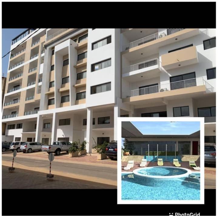 a large building with a swimming pool in front of it at Cosy F3 au point E in Dakar