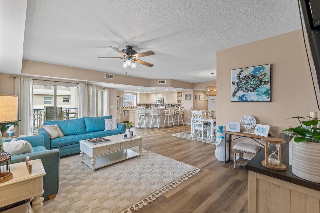 a living room with a blue couch and a table at Oceanwalk 1-401 in New Smyrna Beach