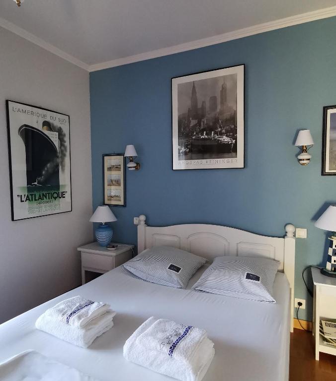 - une chambre avec un lit blanc aux murs bleus dans l'établissement La Pointe de Sel, à Salies-du-Salat