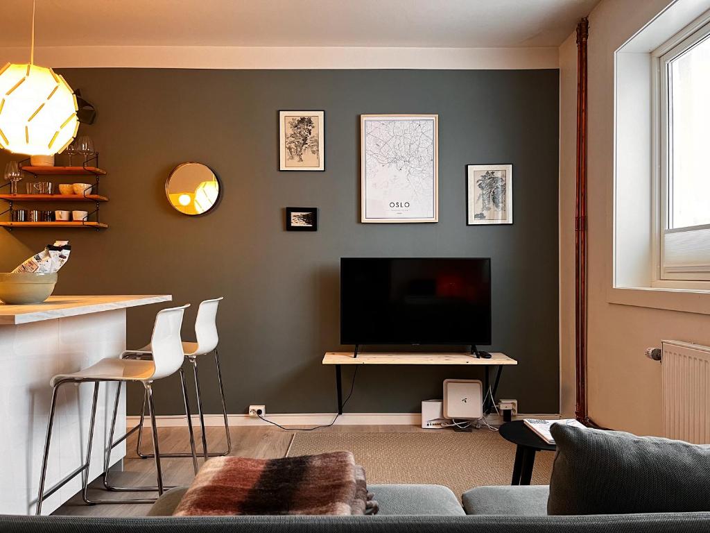 sala de estar con TV, mesa y sillas en Hygge houses I Studio apartment in Lillestrøm I Solo or Couple, en Lillestrøm