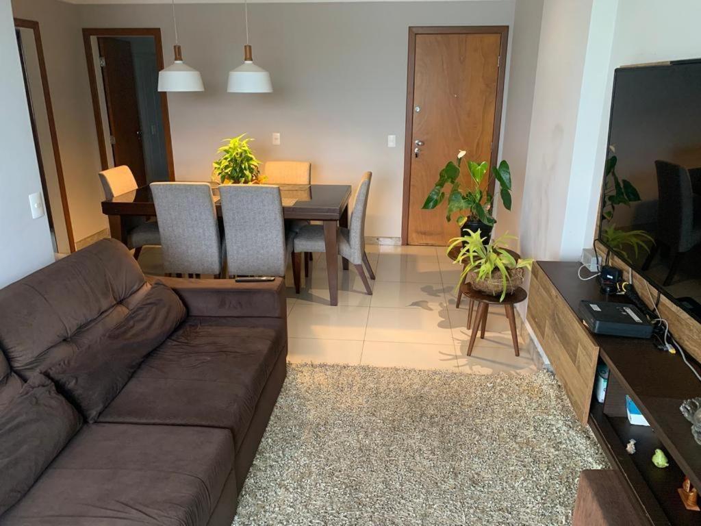 a living room with a couch and a dining table at LINDO APT 3q FRENTE A PRAIA in Guarapari