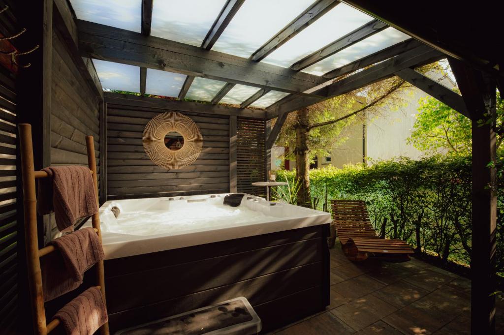 a bathroom with a bath tub under a pergola at Apart House Karwia & Wellness in Karwia