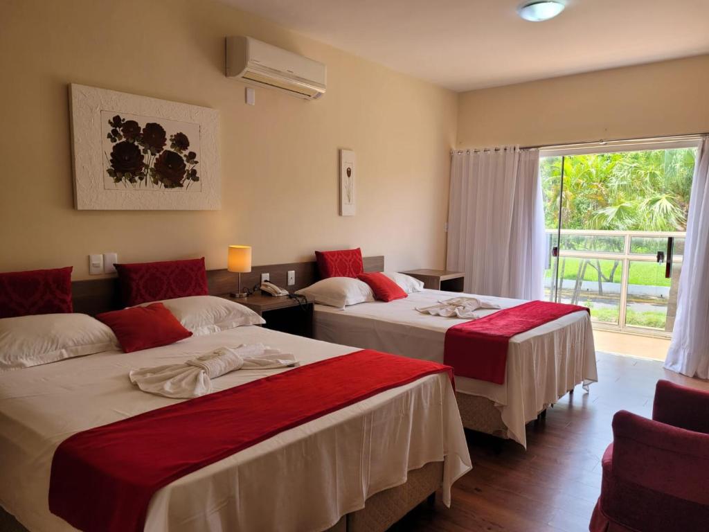 2 camas en una habitación de hotel con ventana en Solarium Park Hotel, en Adamantina