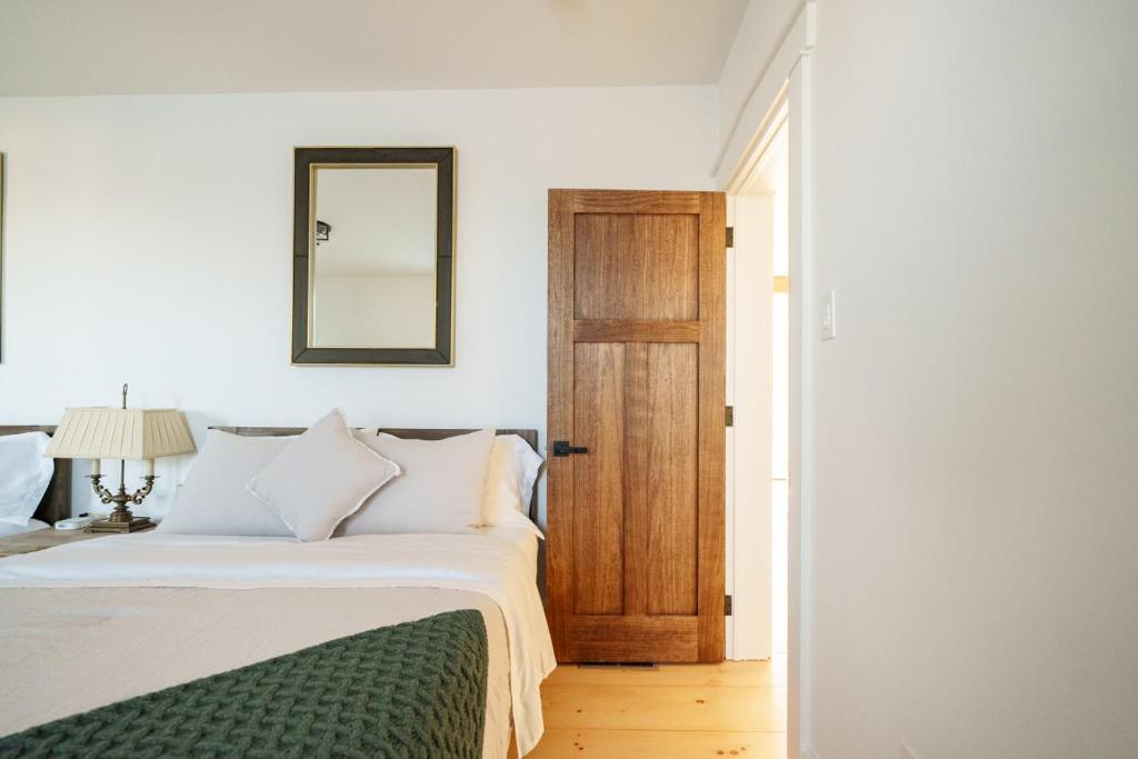 a bedroom with a bed with a mirror and a door at Very Comfy Farmhouse Apartment Unit A, 1st FL in Lancaster