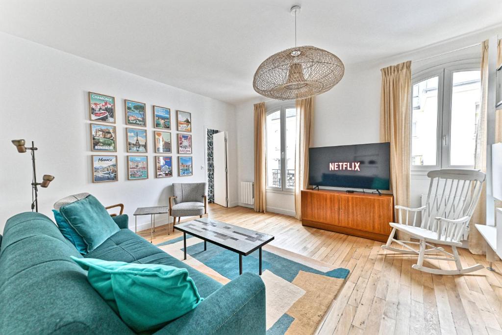 un salon avec un canapé et une télévision dans l'établissement Sublime 2P à 15 min du centre de Paris., à Courbevoie