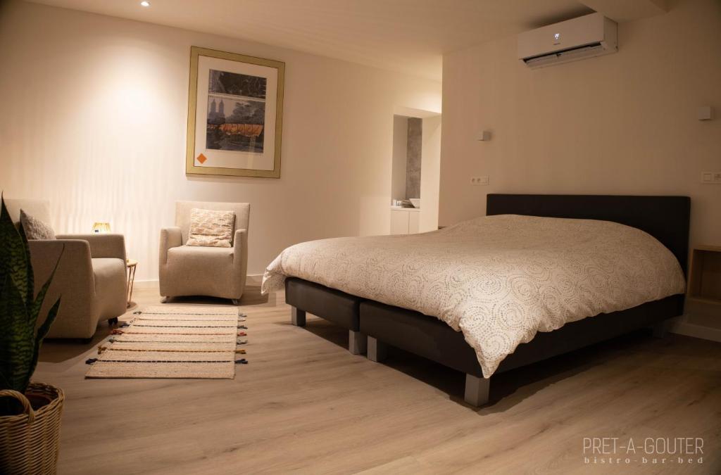 - une chambre avec un lit et une chaise dans l'établissement PRET A GOUTER bistro bar bed, à Heusden-Zolder