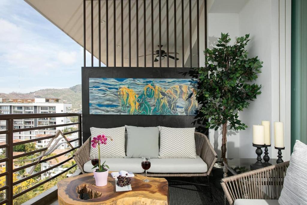 d'une terrasse avec un canapé et une table sur un balcon. dans l'établissement Pinnacle Resorts, à Puerto Vallarta