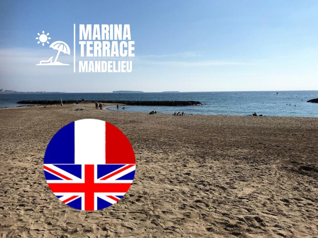 una señal en una playa con bandera británica en Marina Terrace, en Mandelieu-la-Napoule